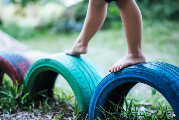 Foto gratuita niños corriendo con neumáticos en el patio de recreo.