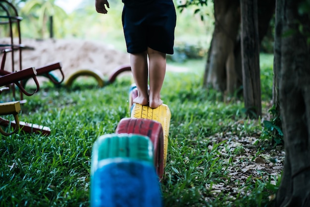 Niños corriendo con neumáticos en el patio de recreo.