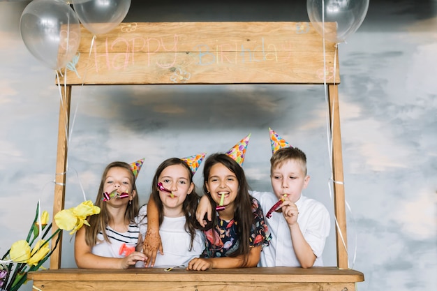 Niños con cuernos de fiesta celebrando cumpleaños