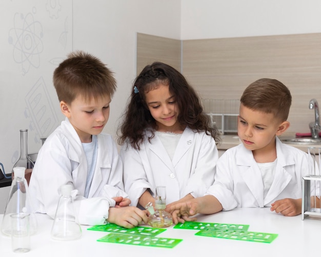 Niños curiosos haciendo un experimento químico en la escuela.