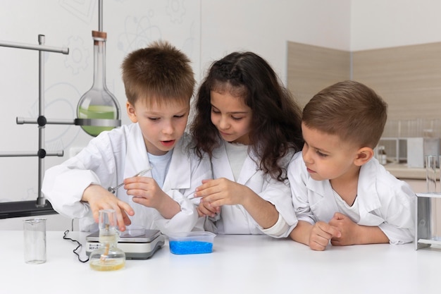 Niños curiosos haciendo un experimento químico en la escuela.