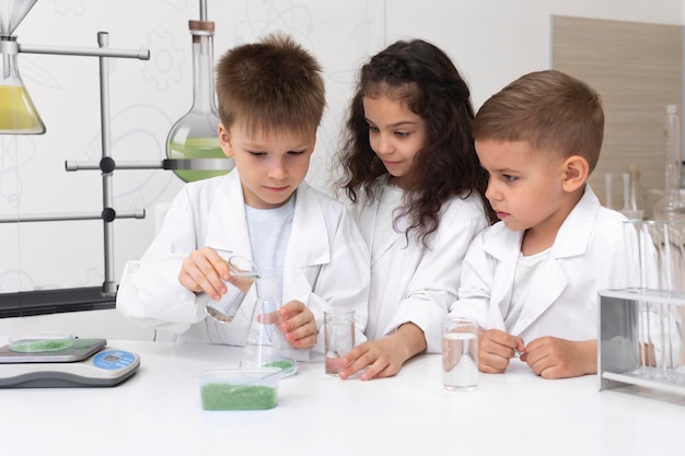 Niños curiosos haciendo un experimento químico en la escuela.
