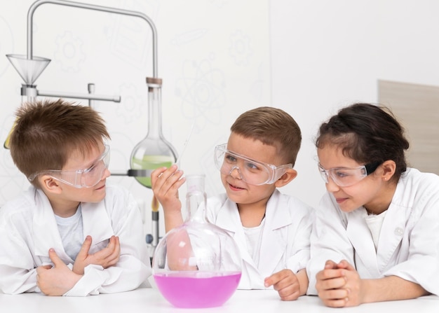 Niños curiosos haciendo un experimento químico en la escuela.