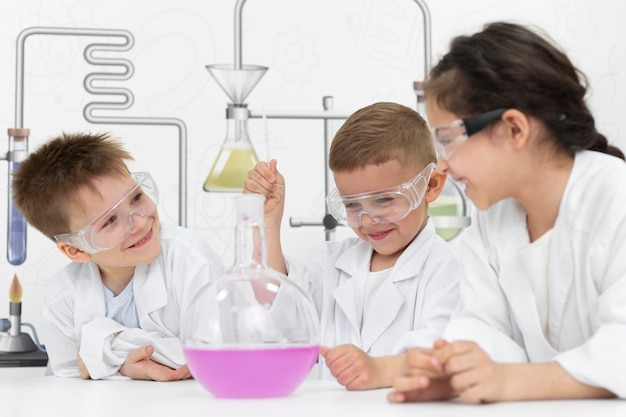 Foto gratuita niños curiosos haciendo un experimento químico en la escuela.