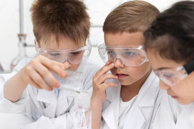 Niños curiosos haciendo un experimento químico en la escuela.