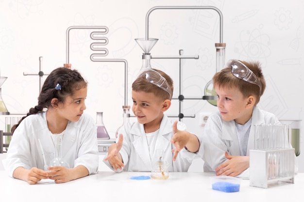 Niños curiosos haciendo un experimento químico en la escuela.