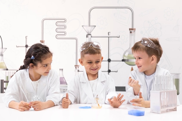 Niños curiosos haciendo un experimento químico en la escuela.