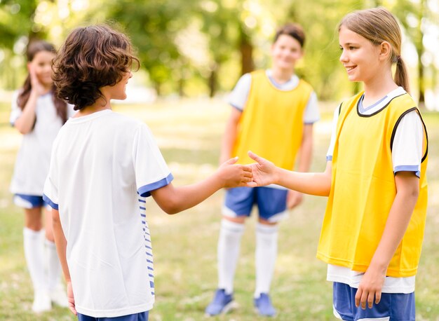 Niños dándose la mano antes de un partido de fútbol