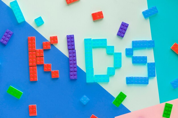 Los niños deletrean palabra con fondo de bloques de plástico