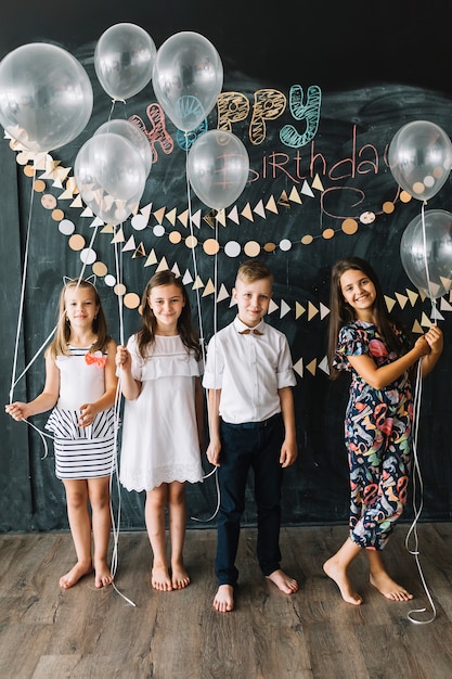 Niños descalzos con globos en la fiesta de cumpleaños