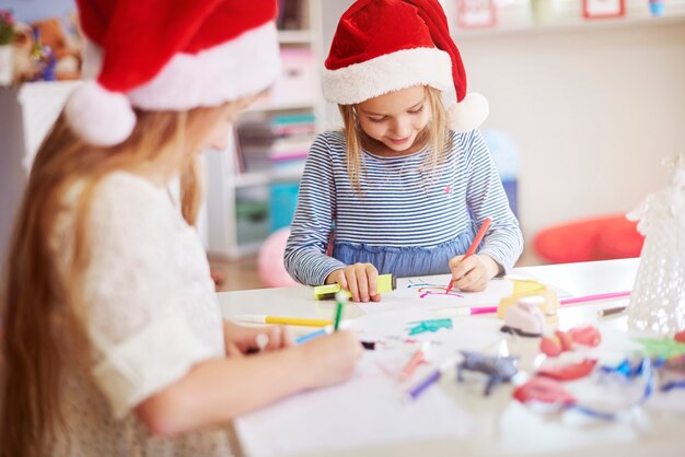 Niños dibujando cuadros navideños