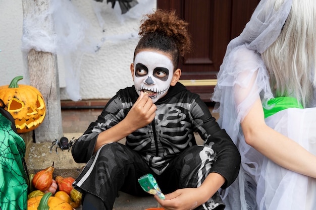 Niños disfrazados comiendo sus dulces.