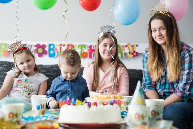 Niños disfrutando de la fiesta de cumpleaños cerca de la mesa dulce