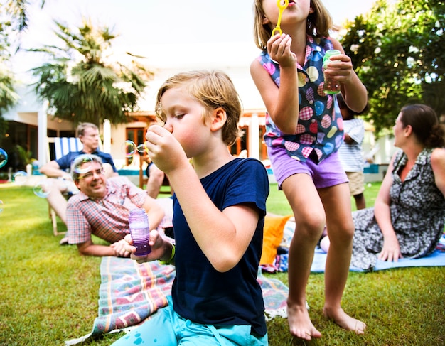 Foto gratuita niños disfrutando de soplar burbujas al aire libre