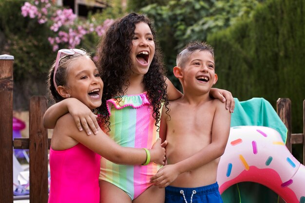 Niños divirtiéndose con un flotador junto a la piscina