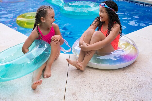 Niños divirtiéndose con flotador en la piscina