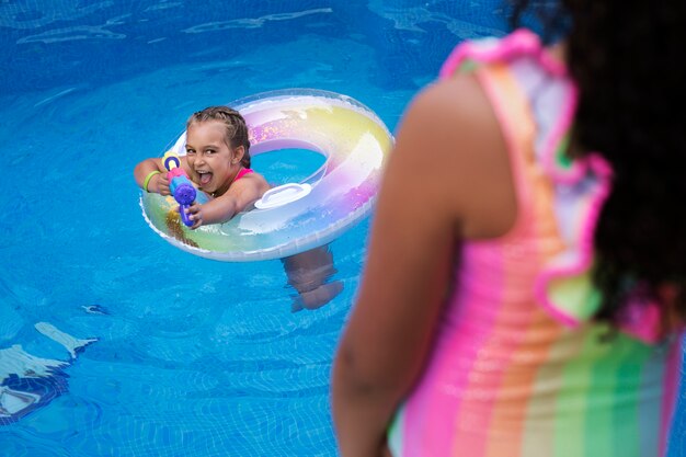 Niños divirtiéndose con flotador en la piscina