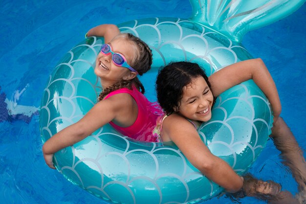 Niños divirtiéndose con flotador en la piscina