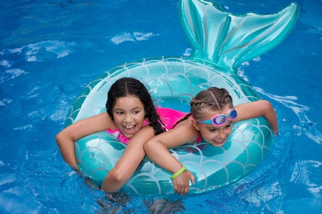 Niños divirtiéndose con flotador en la piscina