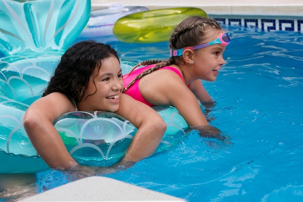 Niños divirtiéndose con flotador en la piscina