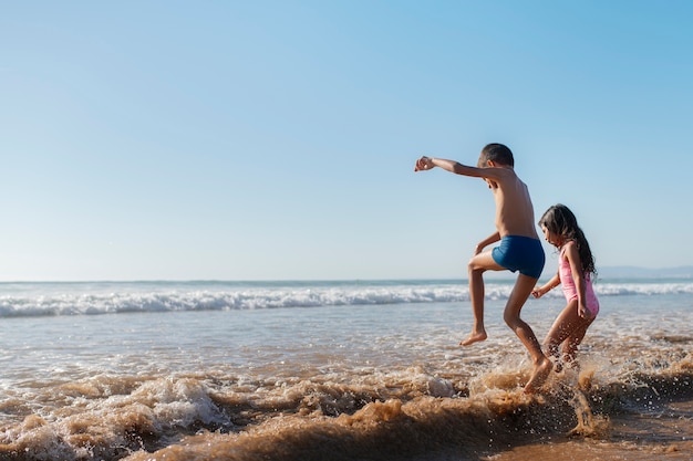 Foto gratuita niños divirtiéndose en la playa