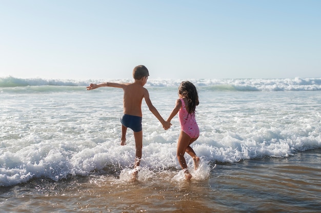 Foto gratuita niños divirtiéndose en la playa