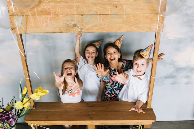 Niños emocionados estirando los brazos en la fiesta de cumpleaños