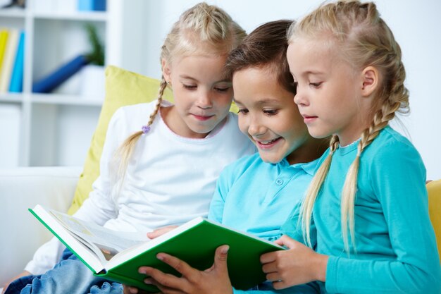 Niños emocionados leyendo un libro