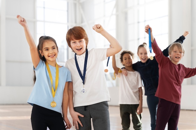 Niños emocionados de tiro medio con medallas