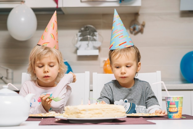 Foto gratuita niños encantadores y pastel de cumpleaños