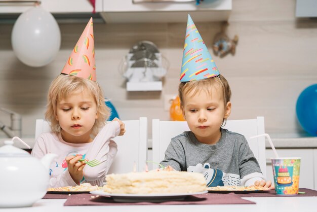 Niños encantadores y pastel de cumpleaños