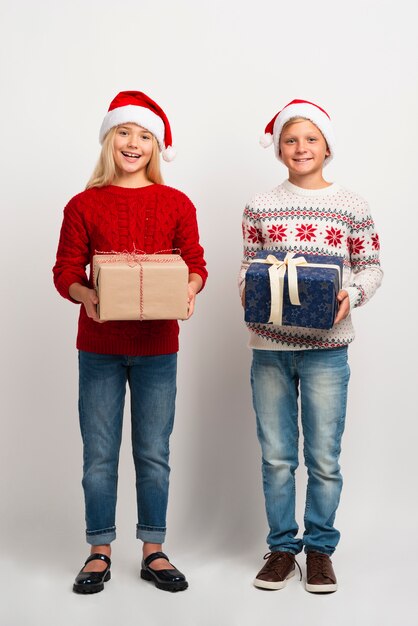 Niños encantadores con regalos de navidad