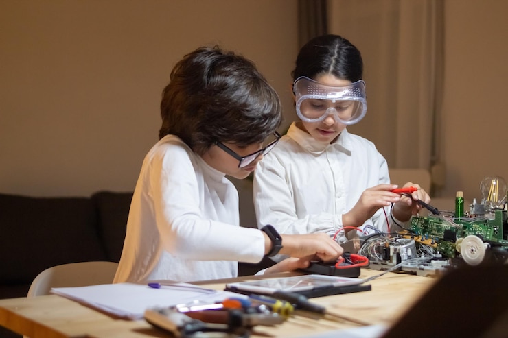 Foto gratuito niños enfocados haciendo experimentos en física juntos