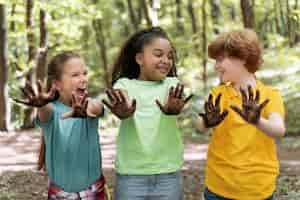 Foto gratuita los niños se ensucian las manos después de plantar