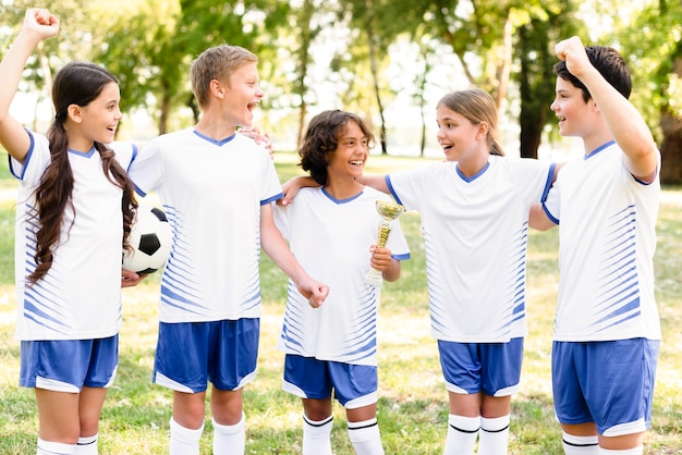 Niños en equipos de fútbol preparándose para un partido al aire libre