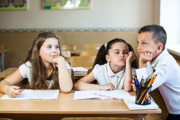 Niños en el escritorio con los libros de texto