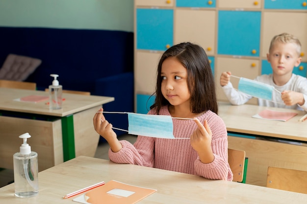 Foto gratuita niños en la escuela durante el concepto de covid.