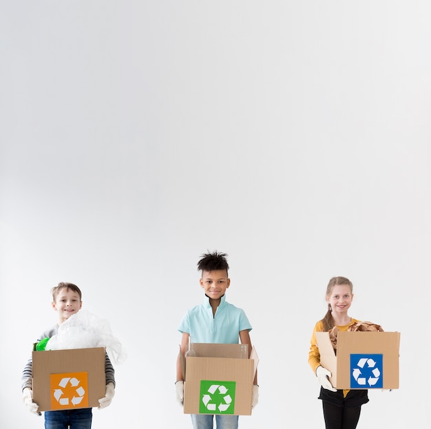 Foto gratuita niños felices con cajas de reciclaje