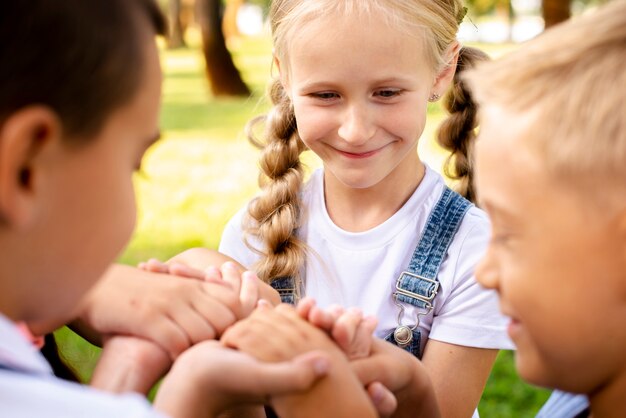 Niños felices con las manos en el parque