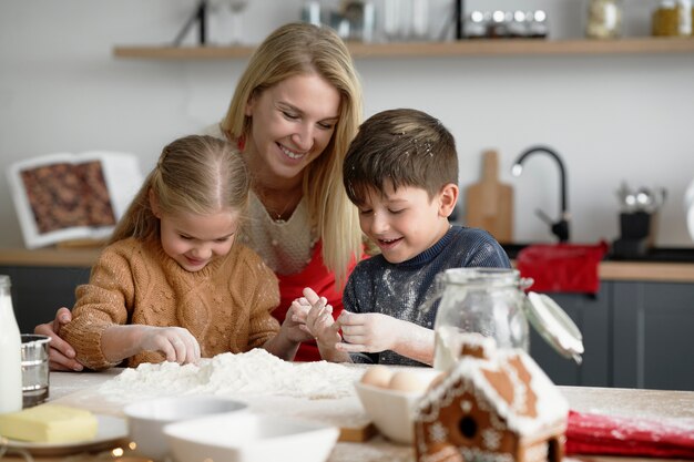 Niños felices pasar tiempo en la cocina con mamá