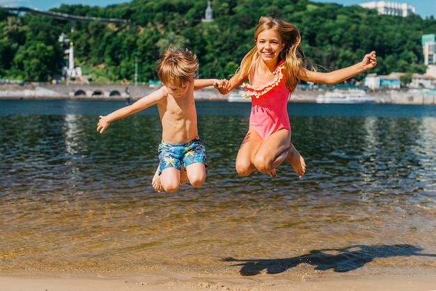 Niños felices saltando en la costa