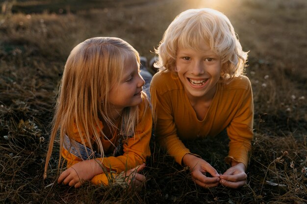 Niños felices de tiro completo sobre el césped