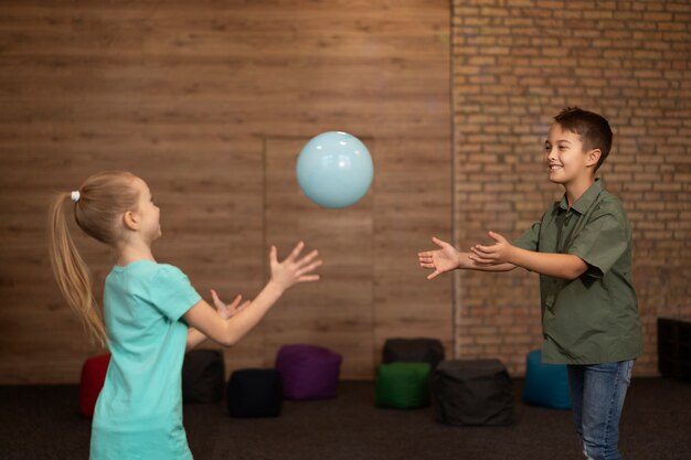 Foto gratuita niños felices de tiro medio jugando con pelota