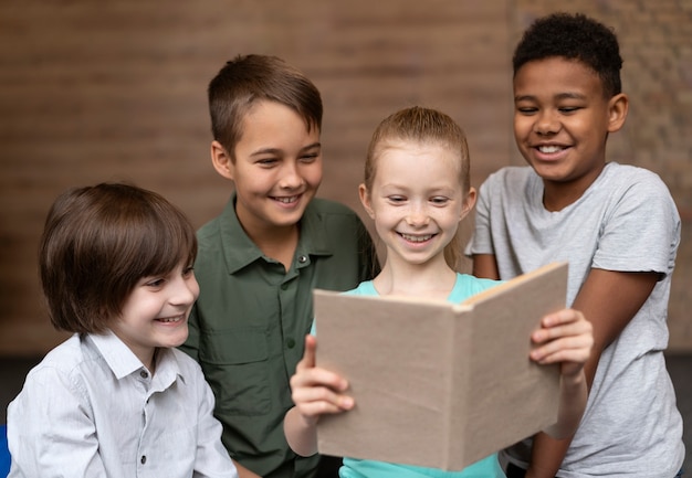 Niños felices de tiro medio leyendo juntos