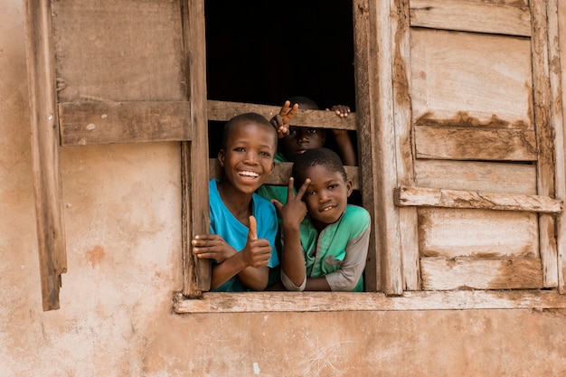 Niños felices de tiro medio en la ventana