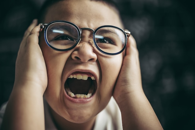 Foto gratuita los niños con gafas escriben libros y piensan en el aula.