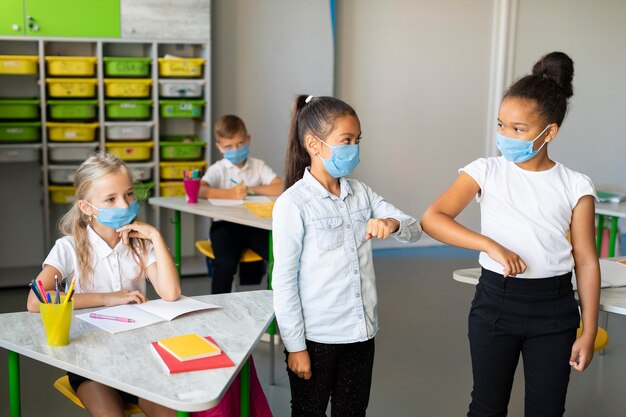 Niños golpeando el codo en el aula