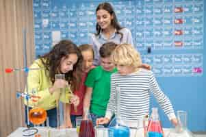 Foto gratuita niños haciendo experimentos químicos y maestros mirando