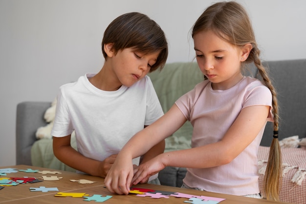 Niños haciendo rompecabezas juntos vista lateral