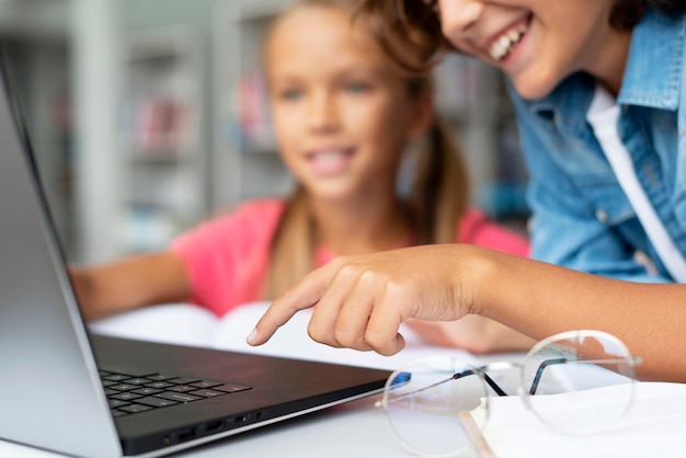 Niños haciendo sus deberes en un primer plano de la computadora portátil